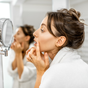 woman examining her face and considering dermal fillers