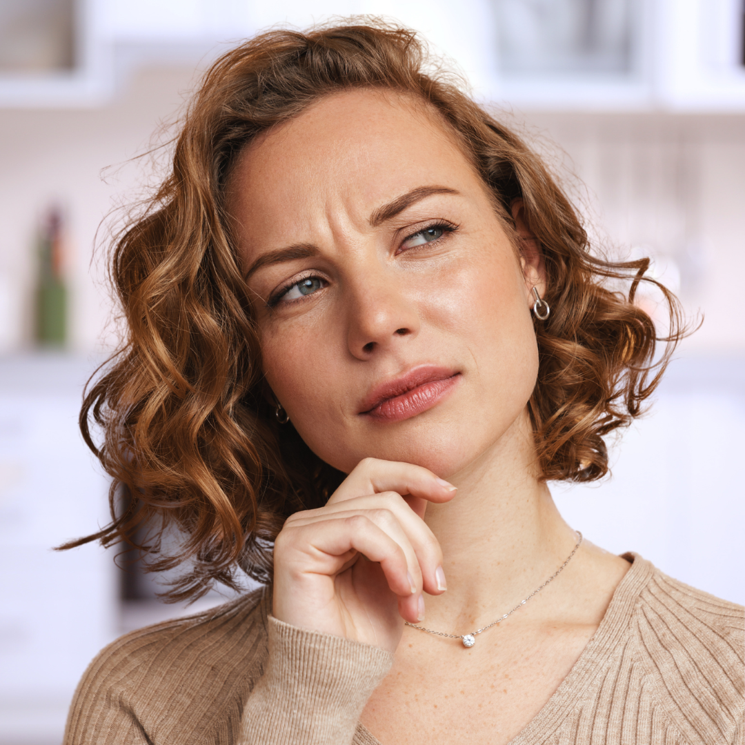 Woman frowning and thinking about having a Botox treatment to smooth out her wrinkles in her forehead.